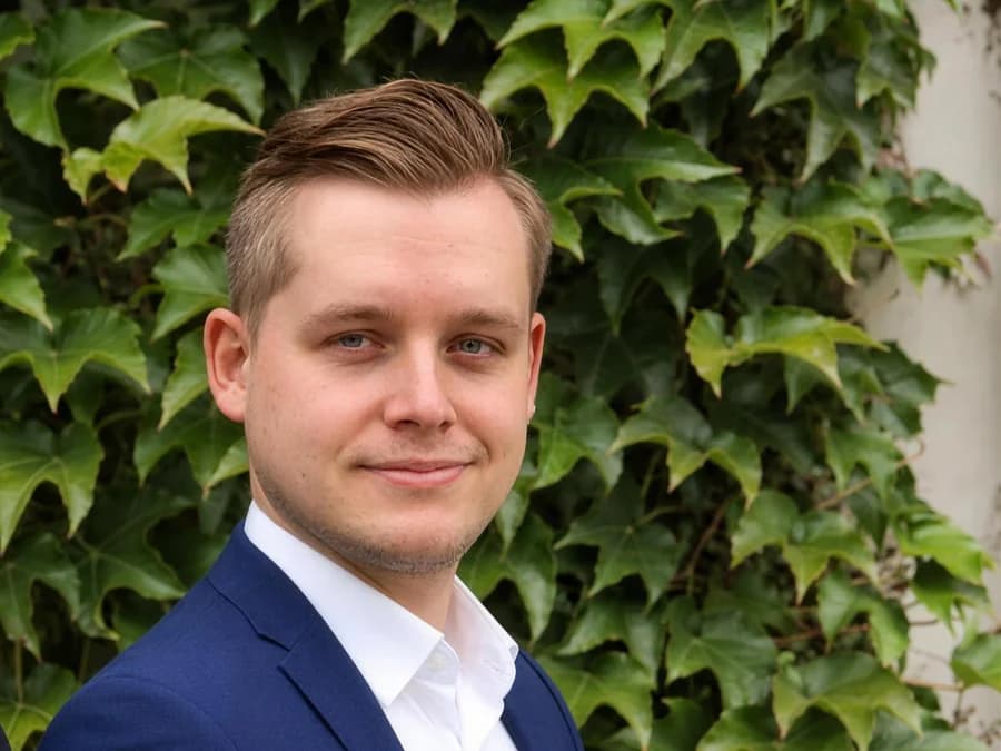 Lucas Weber vor der begrünten Fassade des Büros