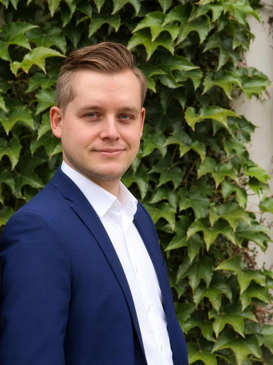 Lucas Weber vor der begrünten Fassade des Büros
