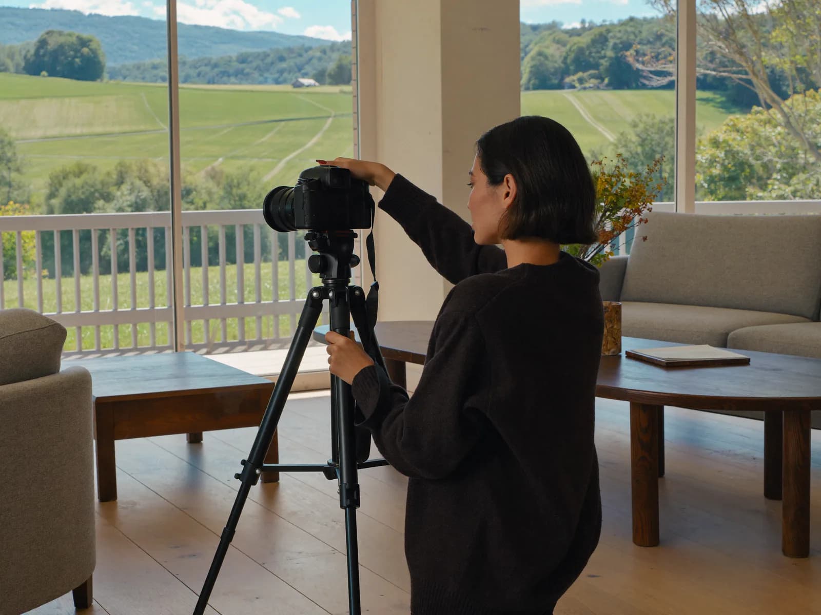 Fotografin fotografiert mit Stativ ein helles Wohnzimmer