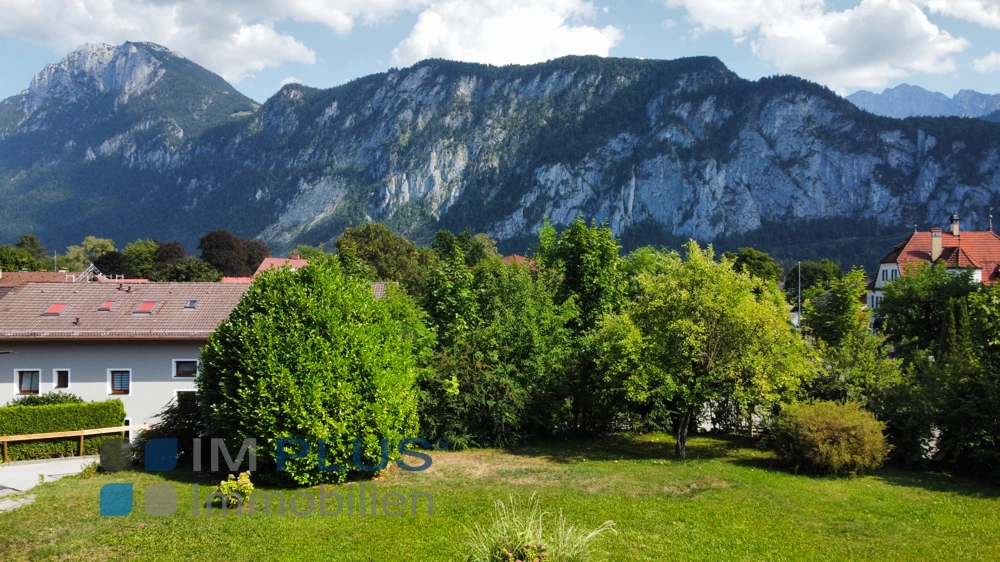 Garten mit Bäumen und Blick auf die Felswände der Berge, Kiefersfelden