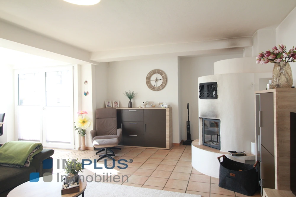 Wohnzimmer mit Kachelofen, Sessel und Sideboard, Großkarolinenfeld